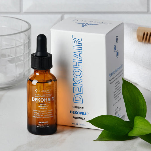 Amber glass dropper bottle and white box of DEKOHAIR scalp treatment serum with green leaves and towel