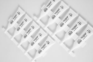 Rows of white DSD Aminopyrrole Melatonin lotion sachets arranged on a white surface